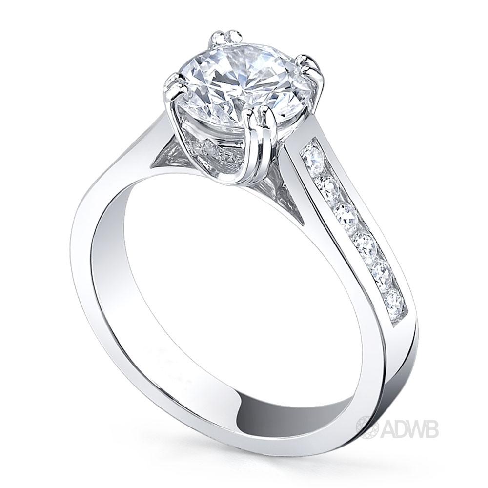 Coco double claw round brilliant cut diamond solitaire ring with channel set diamond band